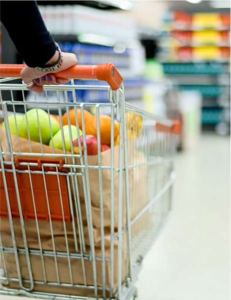 Woman in a supermarket holding shopping cart while grocery shopping