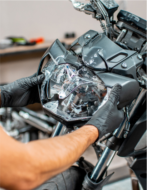 Worker repairing motorcycle headlight in the workshop
